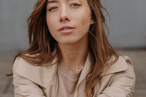 Person meditating outdoors with a serene landscape in the background.